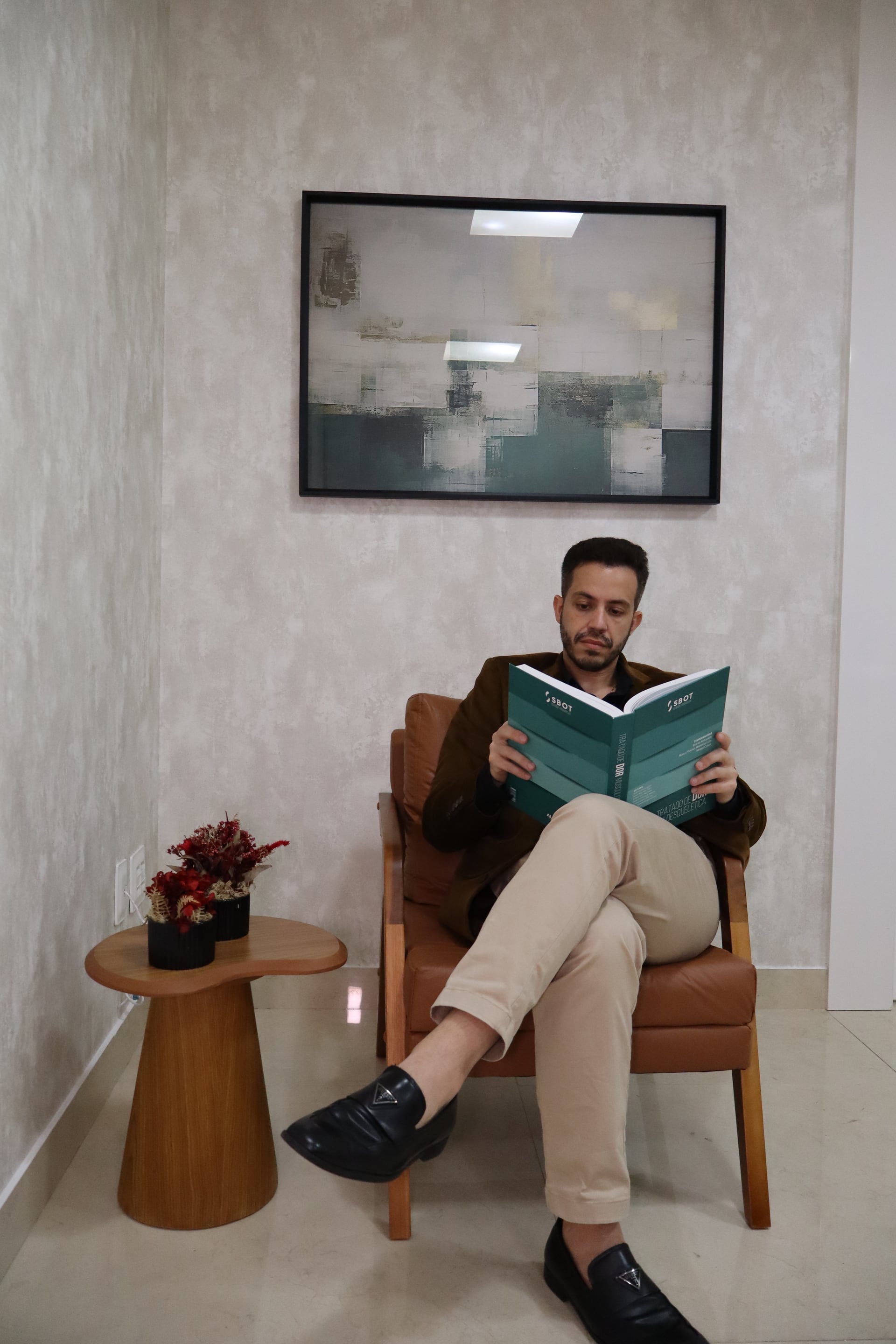 Dr. Diogo em ambiente de recepção e leitura no consultório